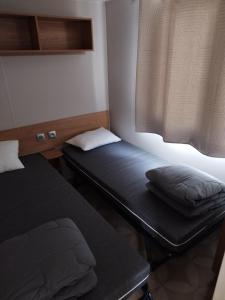 塞里尼昂Mobil home 6/8personnes的小型客房 - 带2张床和窗户