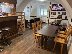 ŽluticeH@M Penzion的一间带桌椅的餐厅和一间酒吧