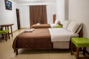 查查波亚斯Hostal La Morada的酒店客房带两张床和一张桌子以及椅子。