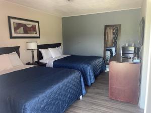 康沃尔Nites Inn Motel的酒店客房设有两张床和电视。