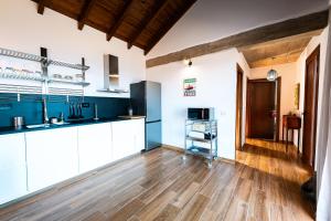 巴尔韦尔德La Candia y el Mar的厨房铺有木地板,配有白色橱柜。
