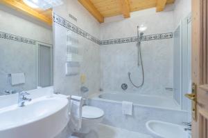 圣克里斯蒂娜Hotel Ciamp的带浴缸、卫生间和盥洗盆的浴室