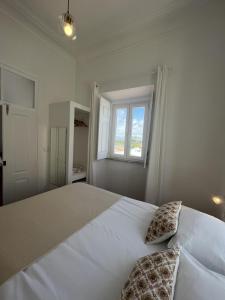 Montes de AlvorGuesthouse Casa Felicia的白色卧室配有一张大白色床和两个枕头