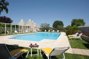 诺奇阿巴特马赛利雅度假酒店的庭院内的游泳池,配有椅子和桌子