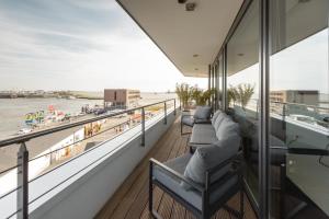 不来梅港Bheaven I Marina Premium Apartment的阳台配有沙发,享有水景