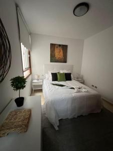 圭马尔港Muy cómodo y cerca de la playa Supreme Puertito 7的卧室配有白色的床和盆栽植物