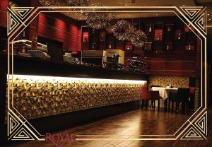 普里什蒂纳Hotel Royal的餐厅设有酒吧,配有桌椅