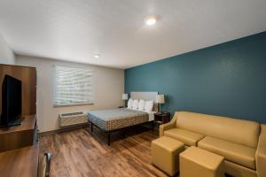 西棕榈滩WoodSpring Suites West Palm Beach的一间配备有沙发、床和电视的客房