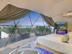 Lago VistaUdoscape Eco-Glamping Resorts的一间卧室设有一张床和一个大窗户