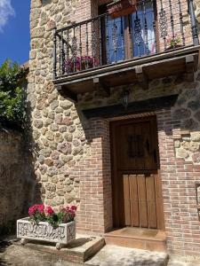 La Casa de Fefita (Stone house in a privileged environment 35 km from Bilbao)的一座带门的建筑和一座鲜花阳台