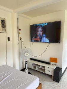 马斯巴特Maria Kulafu Studio Apartment Kinamaligan- Beside Eglin Gas FREE Wifi的卧室配有壁挂式平面电视