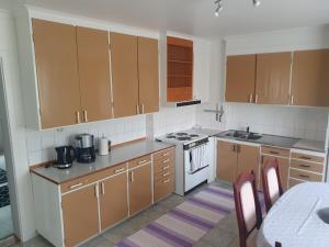 StockaMysig lägenhet för resande的厨房配有棕色橱柜和白色炉灶烤箱