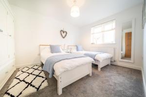 纽基Huckleberry - Premium, Hot Tub, x2 Parking, Farm Shop Next door, Private Cornish Lane的卧室设有2张床和白色的墙壁。