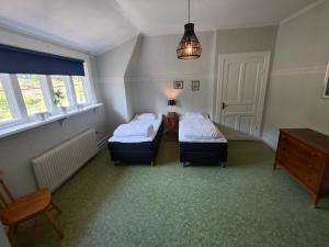 卢德维卡Living Ludvika的客房设有两张床、一张桌子和窗户。