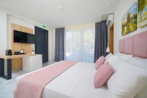 斯卡拉拉乔伊Hotel ASTERA的卧室配有一张带粉红色枕头的大床