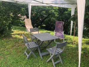 LaveyronLe pti logis的帐篷下野餐桌和四把椅子