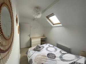 瓦兹河畔欧韦Le Dortoir Daubigny的一间卧室设有一张床、一个窗口和一面镜子