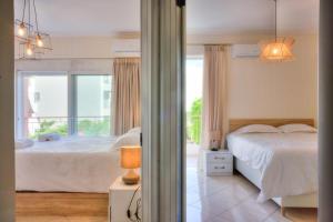 雅典Luxurious 2-bedroom 100m2 Apartment in Elliniko的卧室配有白色的床和窗户。