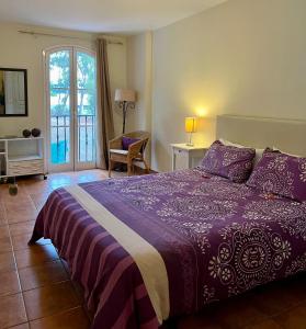 圣乌尔苏拉Lagos de La Quinta的一间卧室设有紫色的床和窗户