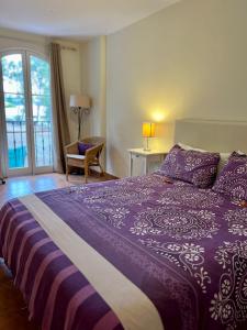圣乌尔苏拉Lagos de La Quinta的一间卧室配有一张紫色床、椅子和窗户