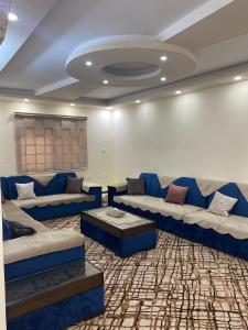 杰拉什Musab apartment的客厅配有蓝色的沙发和桌子