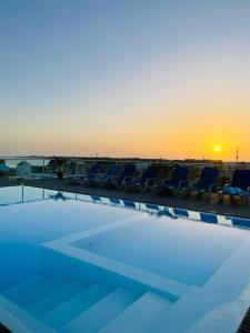 圣玛丽亚Lc Apartments - Sunrise的一个带椅子的游泳池,享有日落美景