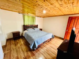 SaboyáHostal Agroturistico Guadalupe的一间卧室设有一张床和木制天花板