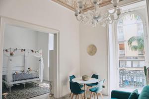 布林迪西Appartamenti Luxury Greco的客厅配有吊灯和桌椅