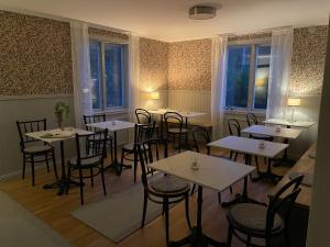 格里斯勒港Pensionat Grisslehamn的用餐室设有桌椅和窗户。