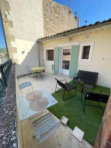 阿普特Appartement+Terrasse en Provence dans le Luberon的房屋内带桌椅的庭院