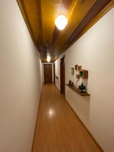 拉夫拉斯诺瓦斯Solar Maria Gomes - Lavras Novas MG的走廊设有木制天花板,房间设有白色墙壁