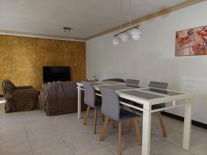 圣马丁Habitación con baño privado y estacionamiento的一间配备有白色桌椅的用餐室