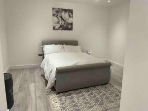 克罗伊登Stylish and Cosy 2 bedroom flat in Croydon的一间卧室配有一张床和一张搁脚凳