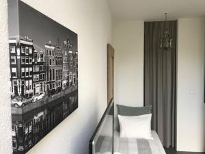 阿姆斯特丹雅堡别墅旅馆的卧室配有一张床,墙上挂着一幅画