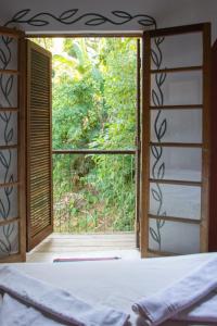 伊利亚贝拉Sambaqui Hostel的卧室设有窗户,俯瞰着花园