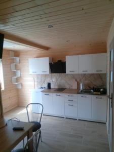 OlszanicaDomki całoroczne Bieszczady的厨房配有白色橱柜和木制天花板