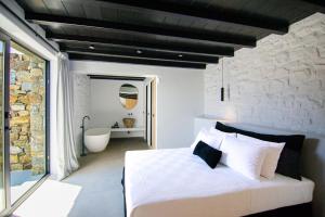卡拉法蒂斯Blue Eye Grand Villa Mykonos的卧室配有白色的床和浴缸