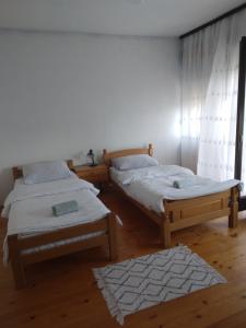 格拉迪什卡Apartmani Primus的一间带两张床的卧室和地毯