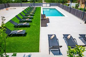 扎达尔KM Exclusive Apartments的一个带椅子的庭院和一个游泳池