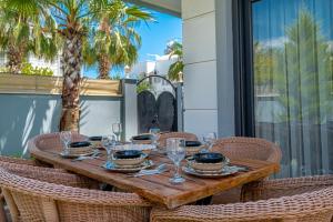 贝莱克Villa w Jacuzzi, Private Pool, Garden in Antalya的一张木桌,上面有玻璃杯和盘子