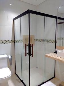 瓜鲁柳斯Guess Hotel & Motel的一间带卫生间的浴室内的玻璃淋浴间