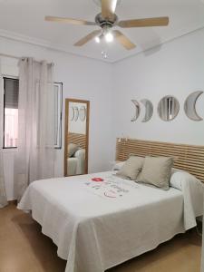 埃尔卡沃德加塔Mi Casita del Cabo的白色卧室配有一张带吊扇的床