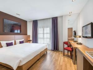 河内河内拉盖尔美居酒店的酒店客房设有一张大床和一张书桌。