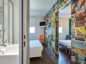 巴黎巴黎沙蒂永门F1酒店的客房设有床、水槽和镜子