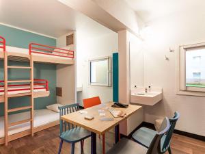 巴黎巴黎沙蒂永门F1酒店的小房间设有桌子和双层床
