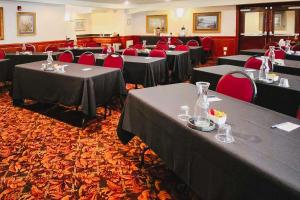 科瓦利斯科瓦利斯康福特套房酒店的一间会议室,配有桌子和红色椅子