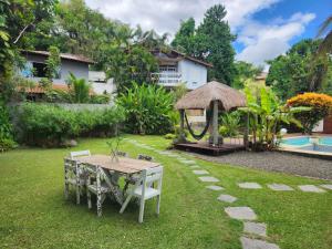 尼泰罗伊Casa Bali 1 2 3的一个带桌子和凉亭的花园
