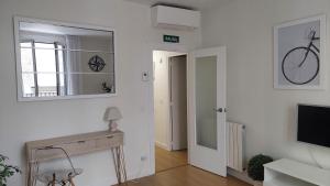潘普洛纳Ibarrenea Apartamento的白色的客厅配有镜子和电视