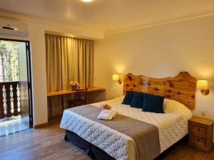 特雷齐蒂利亚斯施耐德酒店的一间卧室配有一张大床和木制床头板