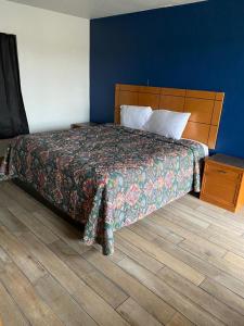 El RenoRanger Motel的一间卧室配有一张床,铺有木地板